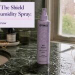 Amika The Shield spray can beside styled hair