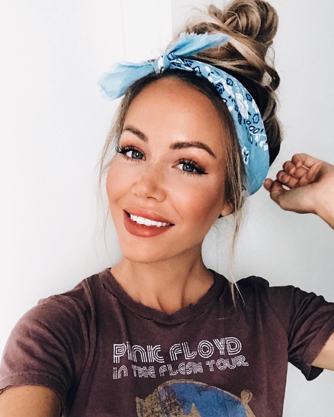 Woman with blonde hair in a high top knot wearing a blue headband.