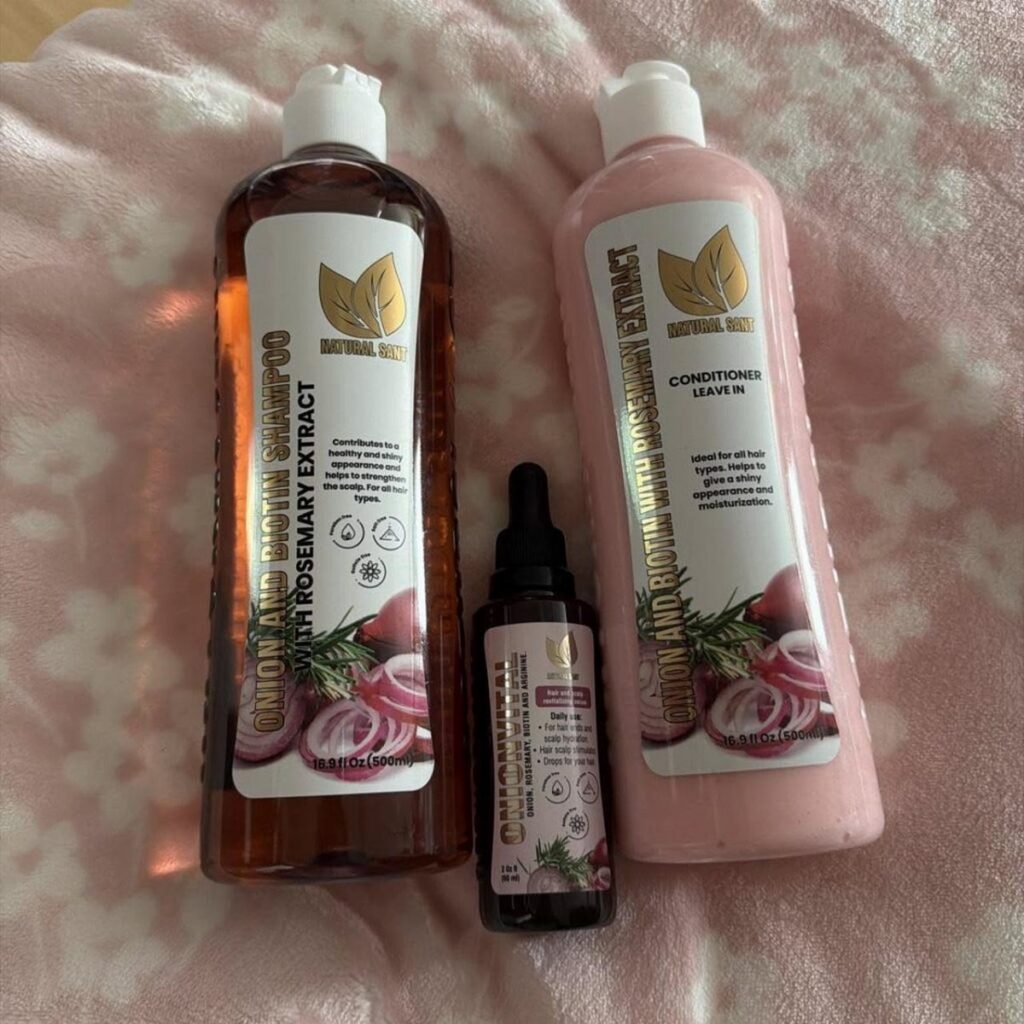 Hair growth shampoo and conditioner bottles with a hair serum on pink fabric.