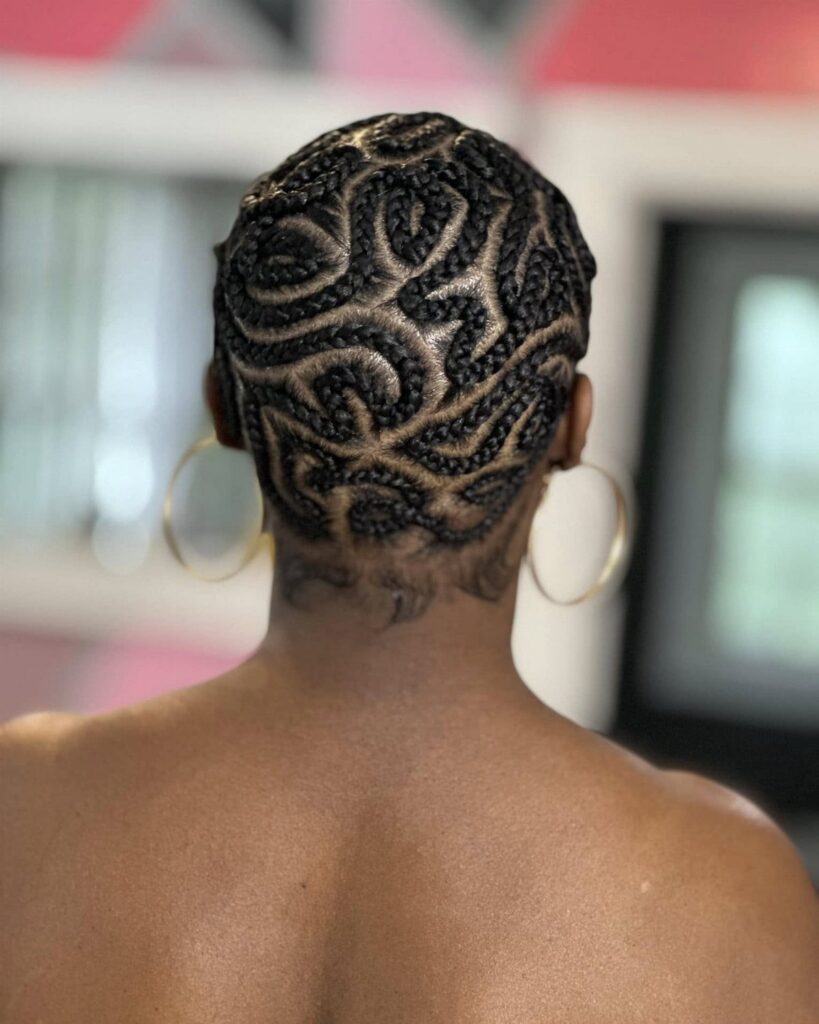 Intricate curved scalp braids on a person's head seen from behind.